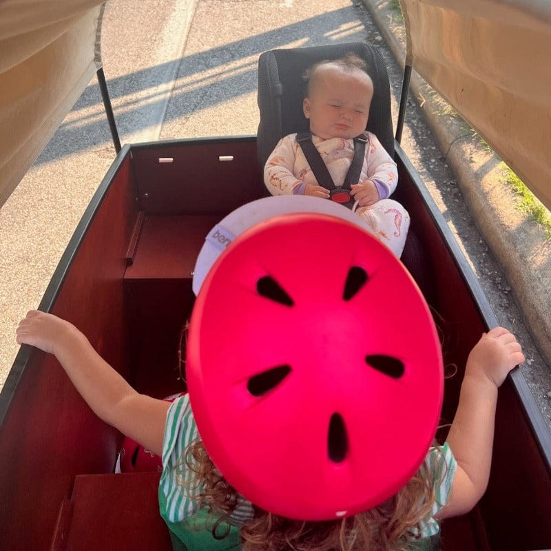 Toddler asleep in toddler seat with older sibling in bunch bike