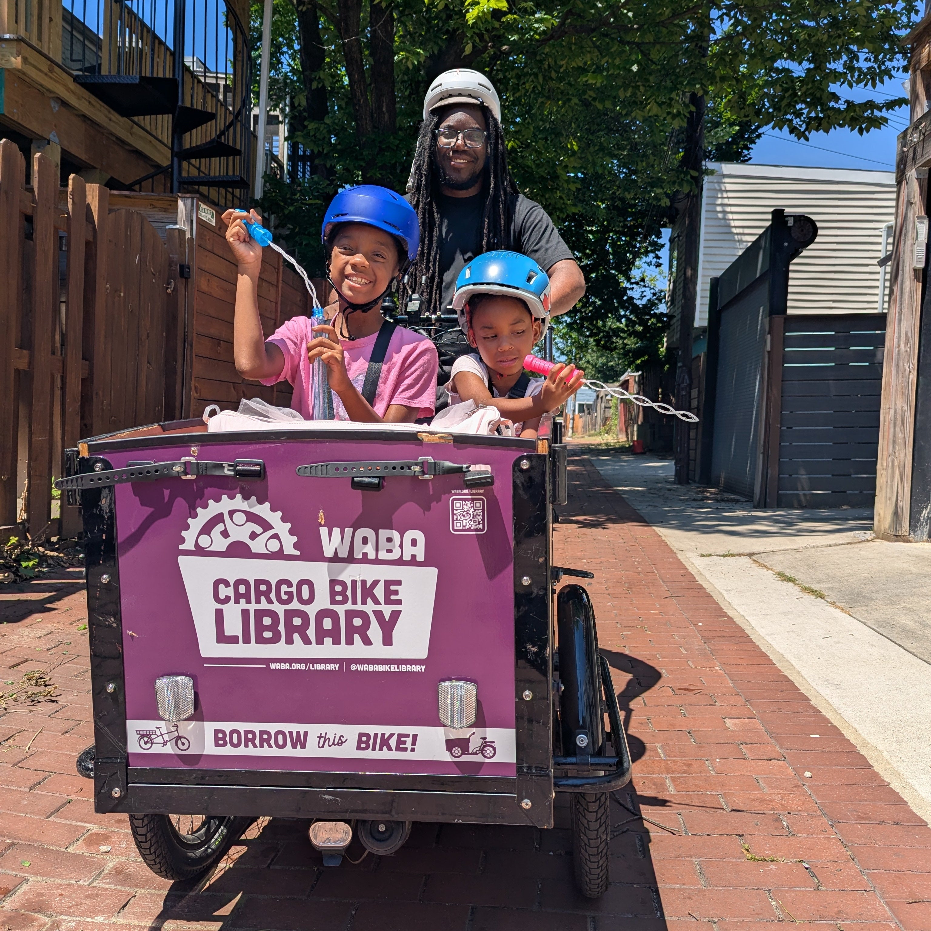 family riding bunch bike waba cargo bike library