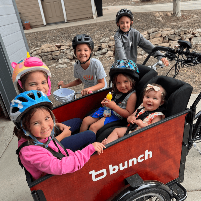 family bike ride with 2 toddlers, 2 older kids in cargo bike and 2 kids on their own bikes #color_Sedona Woodgrain