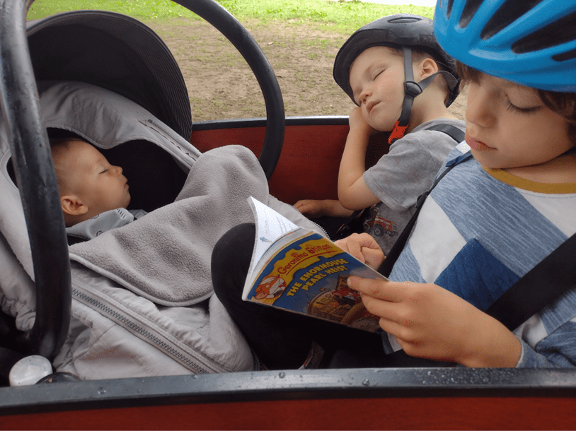 infant asleep in car seat carrier with two siblings in bunch bike #color_Classic Sedona Woodgrain