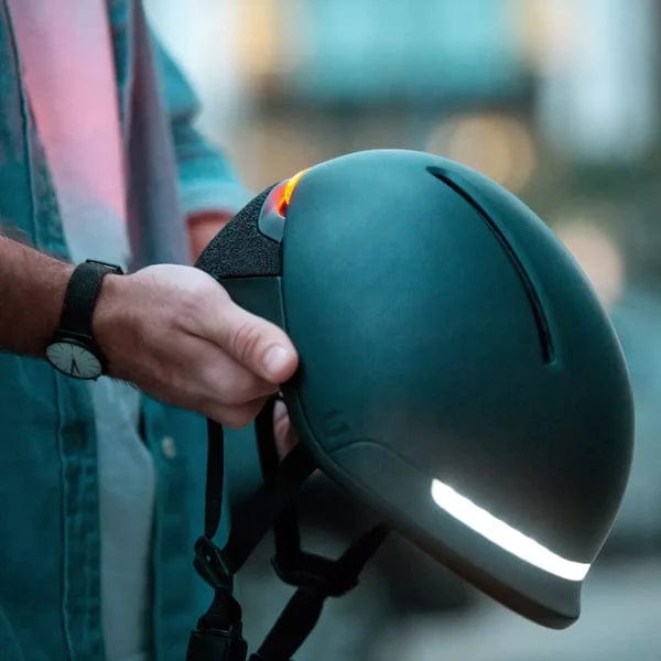 Man holding Faro Smart helmet with headlight on