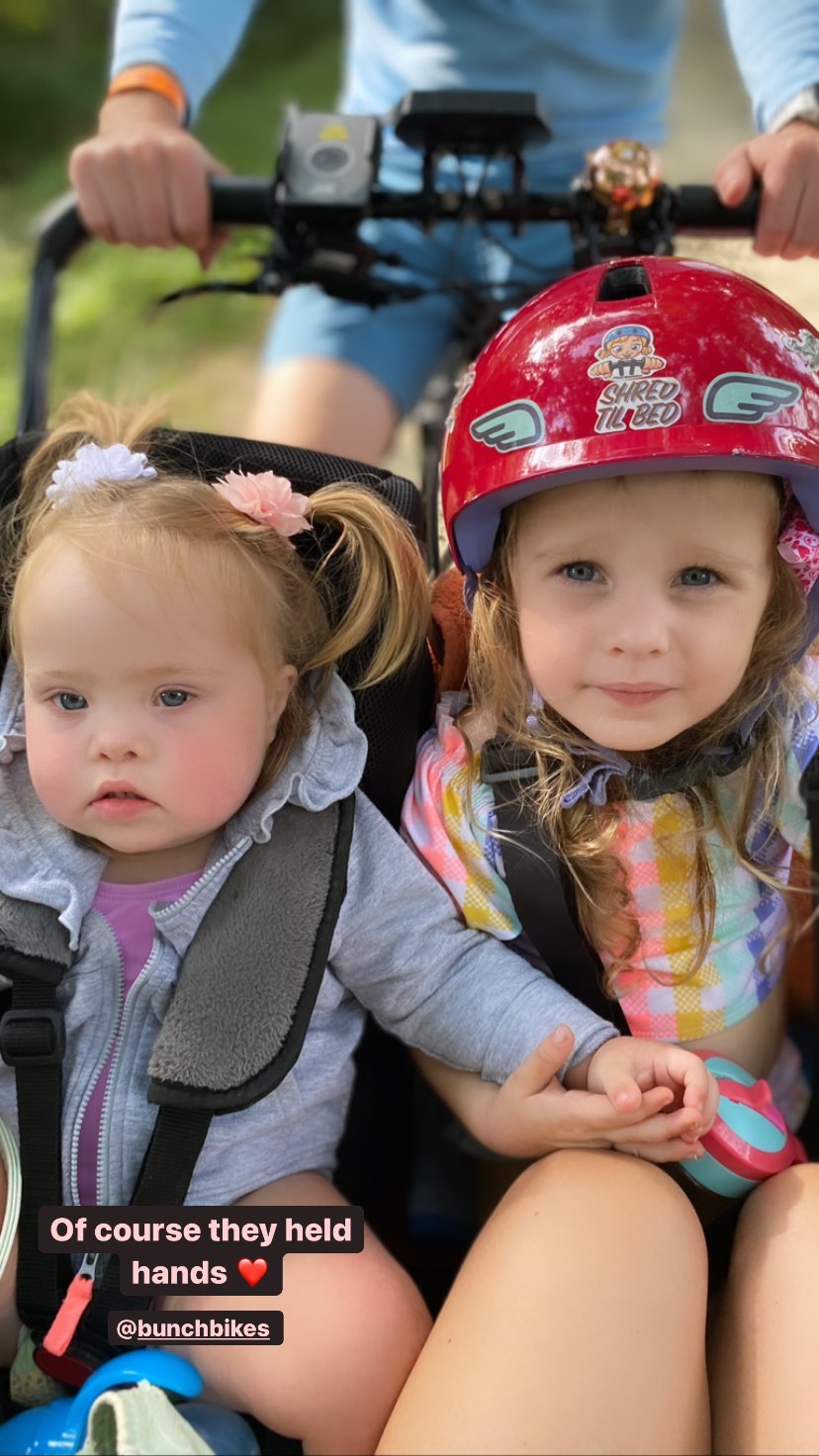 Photo of sisters holding hands in the bunch bike courtesy of @makingmilliestones