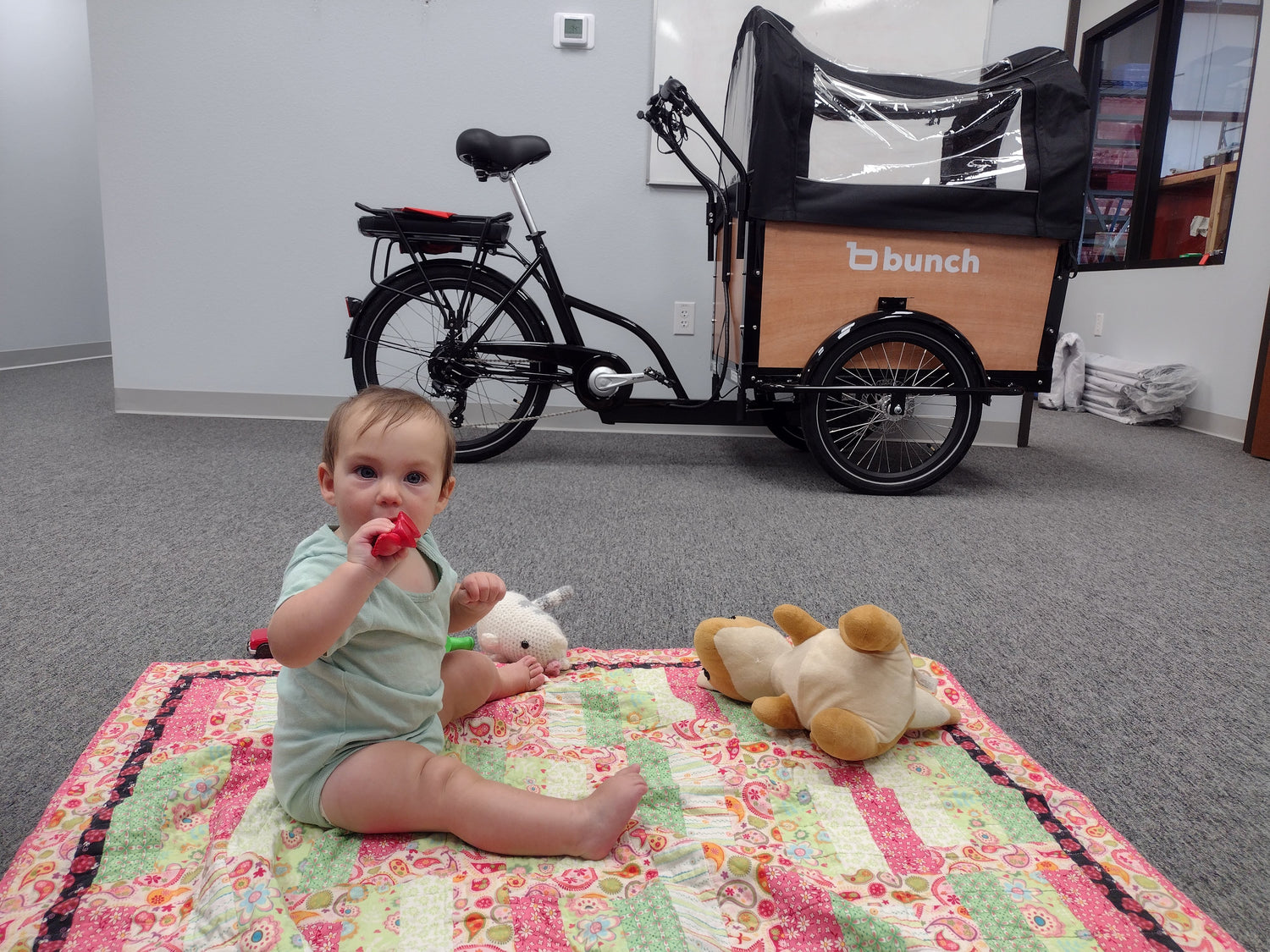 Baby on blanket near bunch bike in Denton headquarters