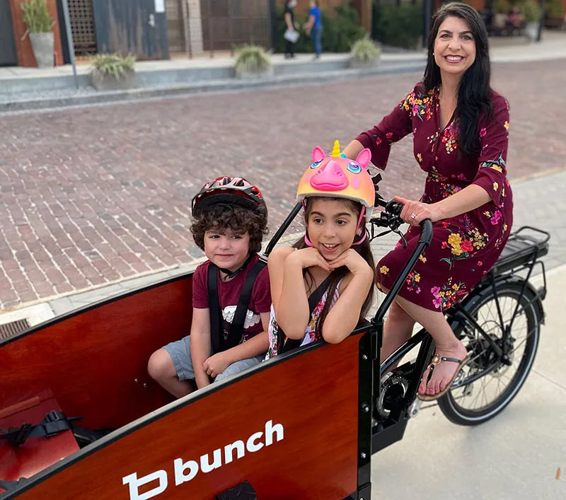 Mom with 2 kids on street riding cargo bike