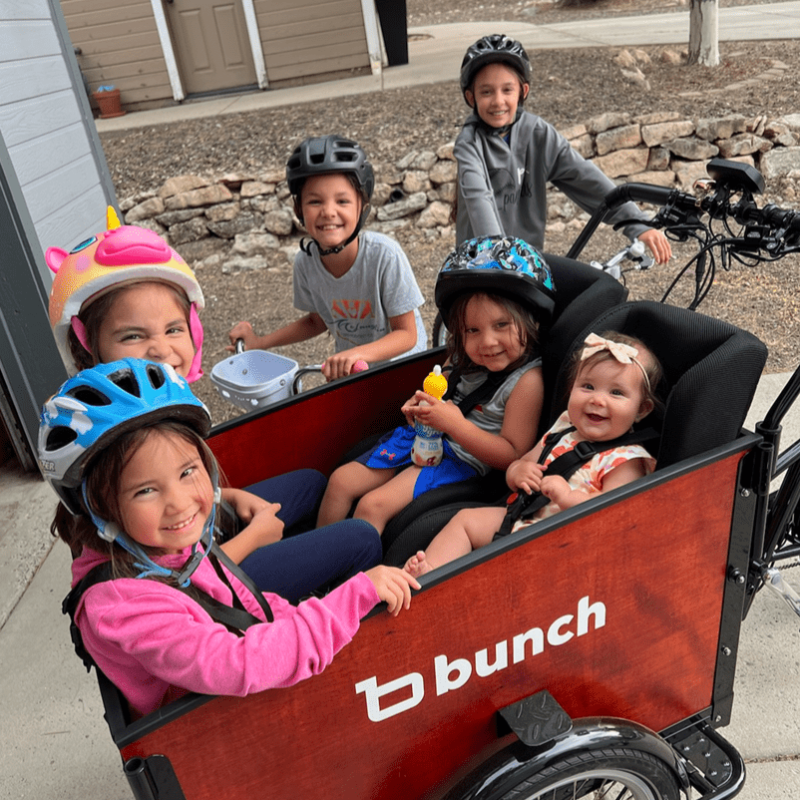 family bike ride with 2 toddlers, 2 older kids in cargo bike and 2 kids on their own bikes  #color_Classic Sedona Woodgrain